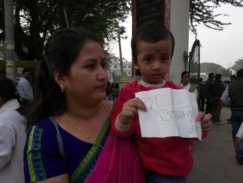Portrait of cute boy holding girl standing outdoors