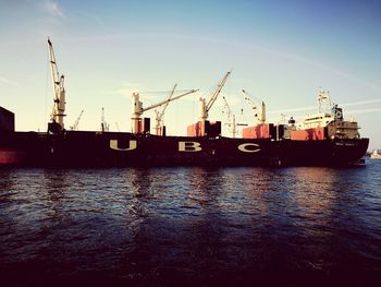 Boats moored at harbor against sky