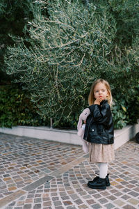 Full length of young woman standing against plants