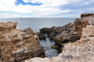 Rock formation by sea against cloudy sky at cape peron