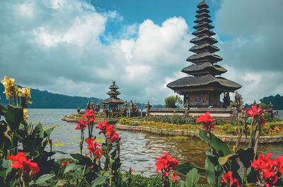 Panoramic view of temple by building against cloudy sky