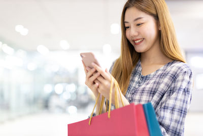 Smiling young woman holding umbrella