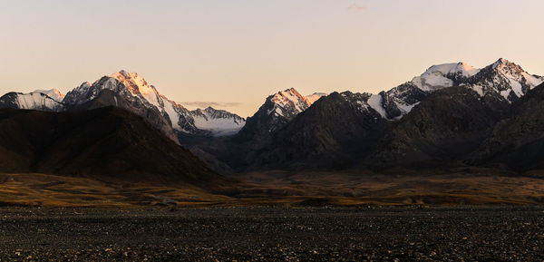 Scenic view of snowcapped mountains against sky during sunset