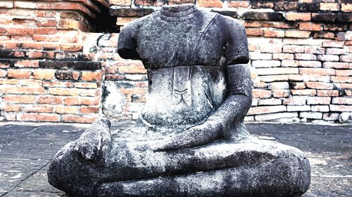 Statue against stone wall