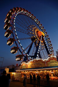 Low angle view of ferris wheel against clear sky at night