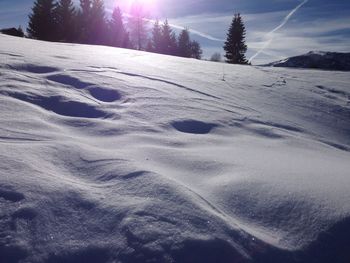 Snow covered landscape against sky