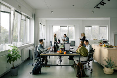 Male and female corporate business professionals working together at office