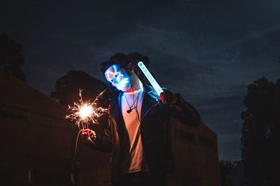 Man holding umbrella at night