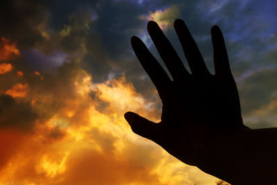 Low angle view of silhouette hand against sky during sunset