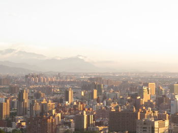 Aerial view of buildings in city against sky