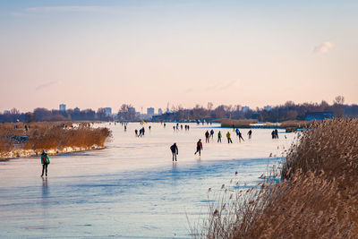 People on beach against sky during winter