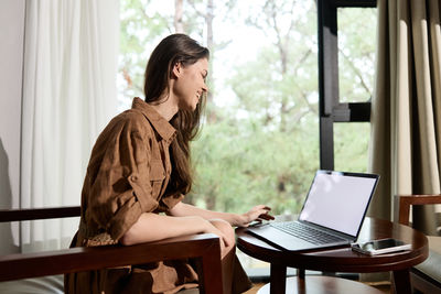 Young woman using laptop at home