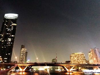 Low angle view of illuminated cityscape against sky at night