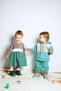 Baby fashion. unisex gender neutral clothes for babies. two cute baby girls in neutral color