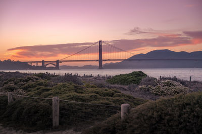 Scenic view of sea and golden gate bridge against sky during sunset