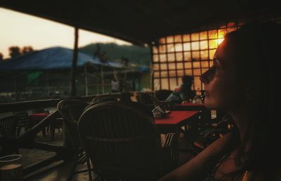 Thoughtful woman in restaurant during sunset