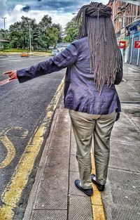 Rear view of woman walking on road