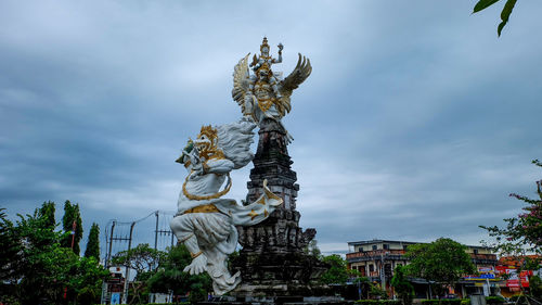 Low angle view of angel statue against sky