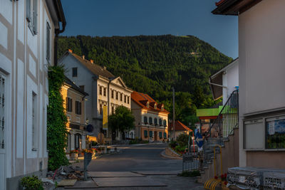 Street amidst houses and buildings against sky