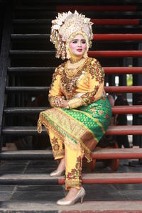 Woman in traditional clothing sitting on steps