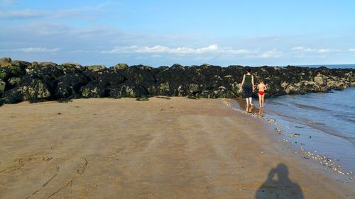 Rear view of mother with son at beach