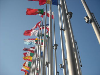 Low angle view of flags hanging against clear sky