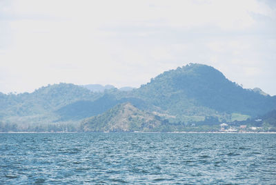 Scenic view of sea and mountains against sky