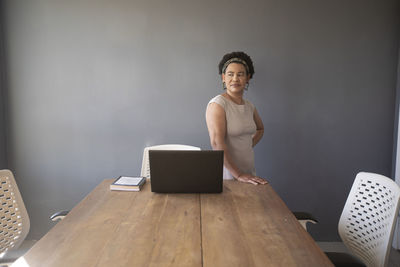 Young man using mobile phone while sitting on table