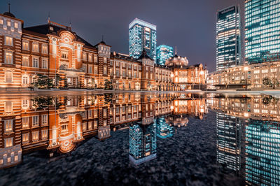 Reflection of buildings in city at waterfront