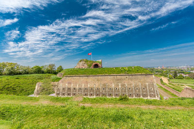 Built structure on field against blue sky of fort sint pieter on mount st. peter or sint-pietersberg