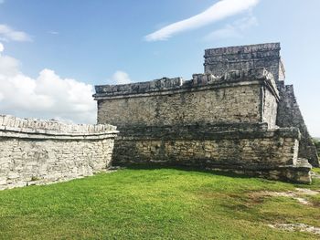 View of maya temple in tulum against cloudy sky