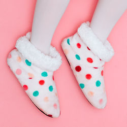 Low section view of polka dot shoes against pink background