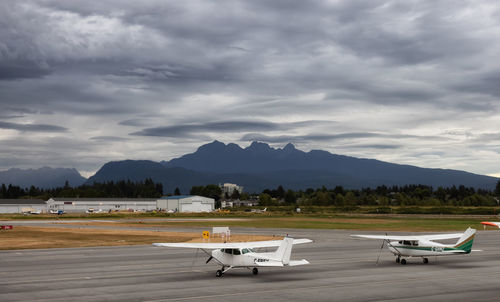 Airplane on airport runway against sky