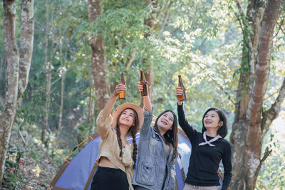 Group friends together at holidays drinking beer and having fun in camping