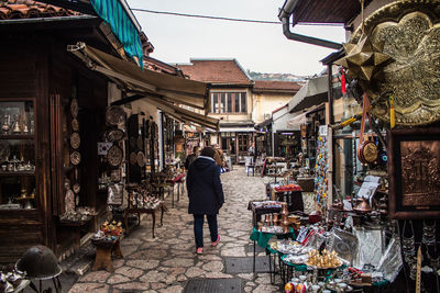 Rear view of woman walking on street market