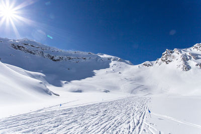 Scenic view of snowcapped mountains against blue sky