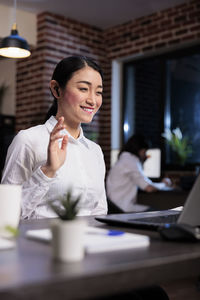 Portrait of smiling businesswoman using laptop at office