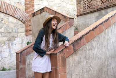 Young woman standing against wall