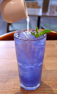 Fresh lime juice being added into iced butterfly pea flower tea created color changing