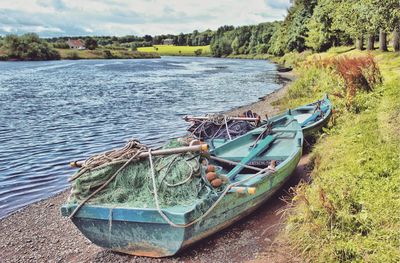 Boats moored in lake against sky