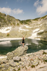 Man standing on rock by mountain