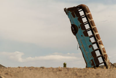 Abandoned bus on field against sky