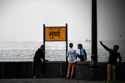 People in sea against sky