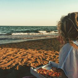 Woman enjoying pizza on beach