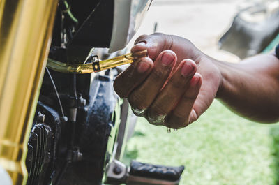 Cropped hand of person working on motorcycle