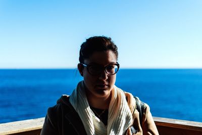 Portrait of young woman against sea