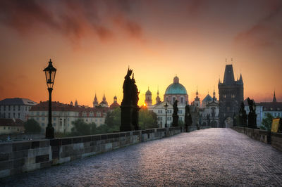 Historic buildings against cloudy sky during sunset