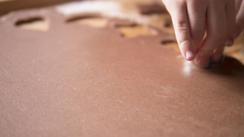 Cropped hand of woman cutting dough