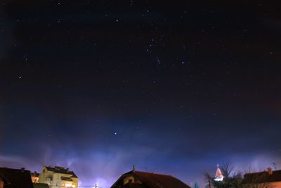 Low angle view of buildings against sky at night