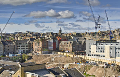 Buildings in city against cloudy sky